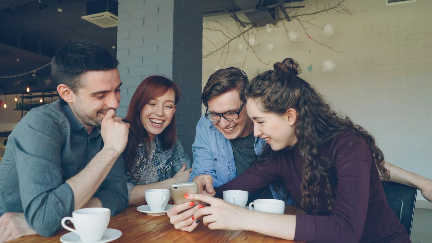 Friends smiling together over a message on a phone
